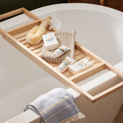 Bathtub with bath caddy or tray holding bath products