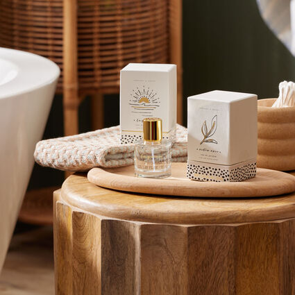 Wooden stool in bathroom with hand towel and room fragrance displayed