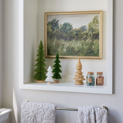 Recessed bathroom storage area with wall art and decorative holiday objects inside