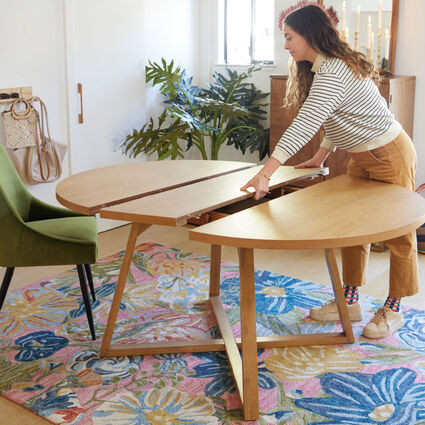 A round dining table with an extendable leaf