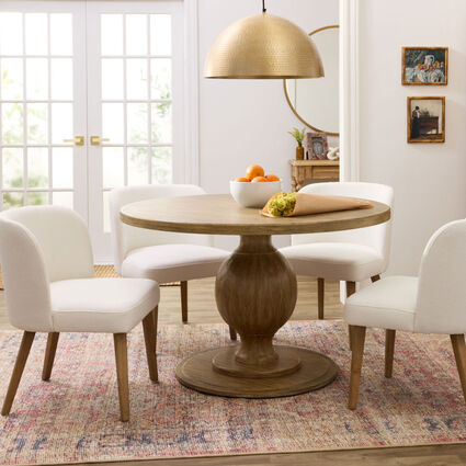 A dining area featuring a small round table with a pedestal base