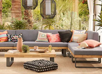 grey outdoor couch with decorative pillows and wooden coffee table